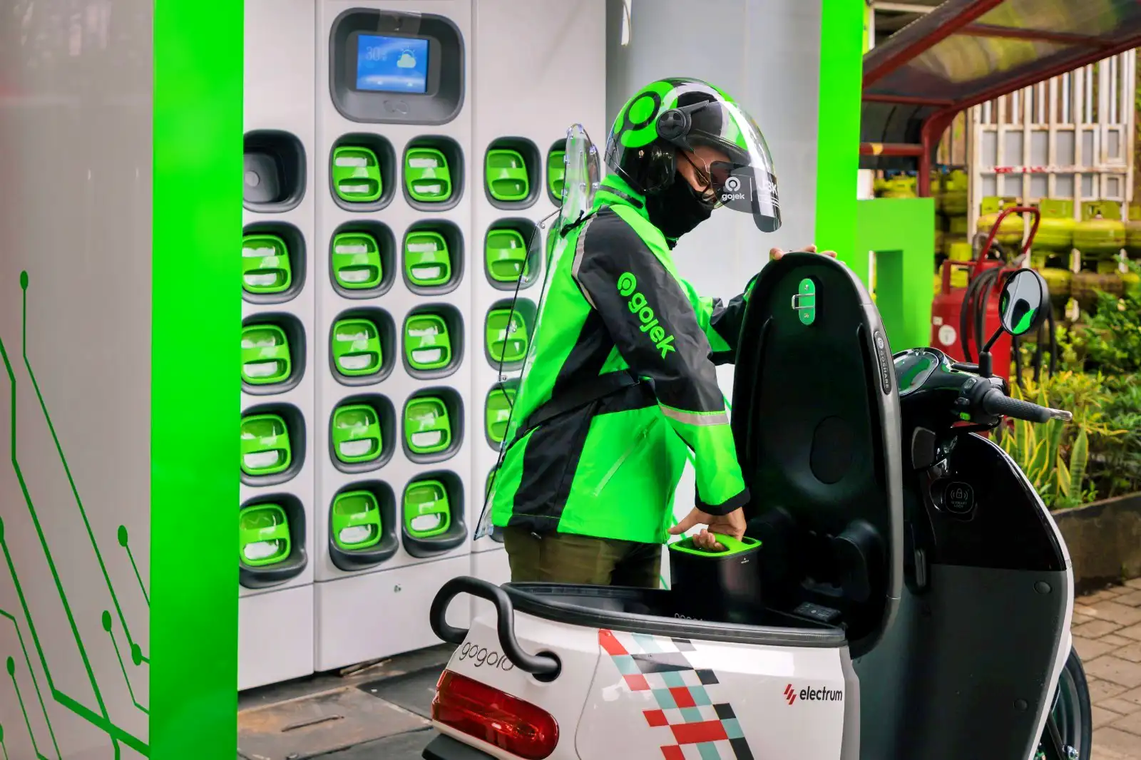 Ilustrasi: Pengendara Gojek tengah mengisi ulang baterai motor listrik. (Foto: Dok. GoTo)